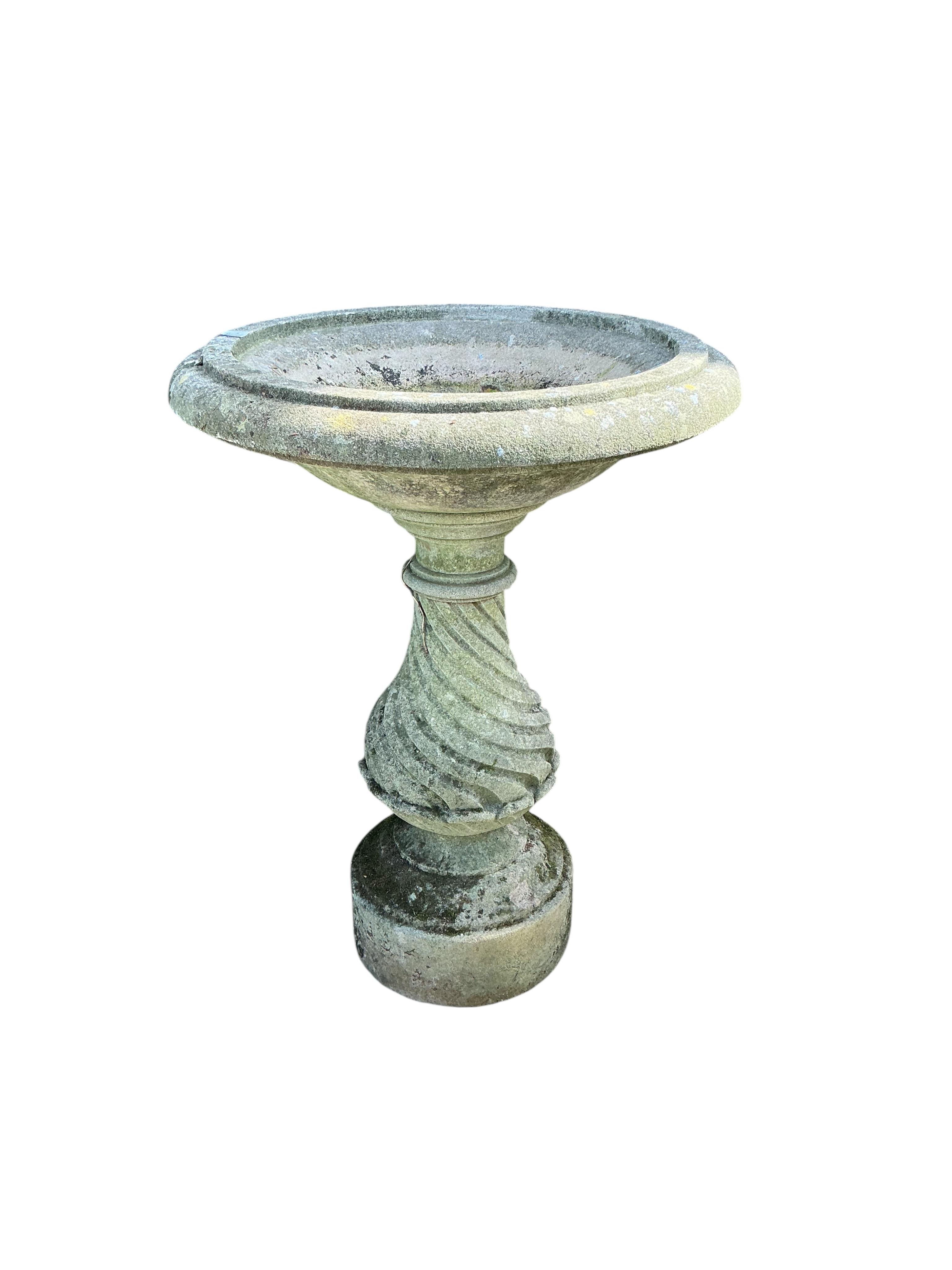 A circular reconstituted stone birdbath, diameter 68cm, height 92cm